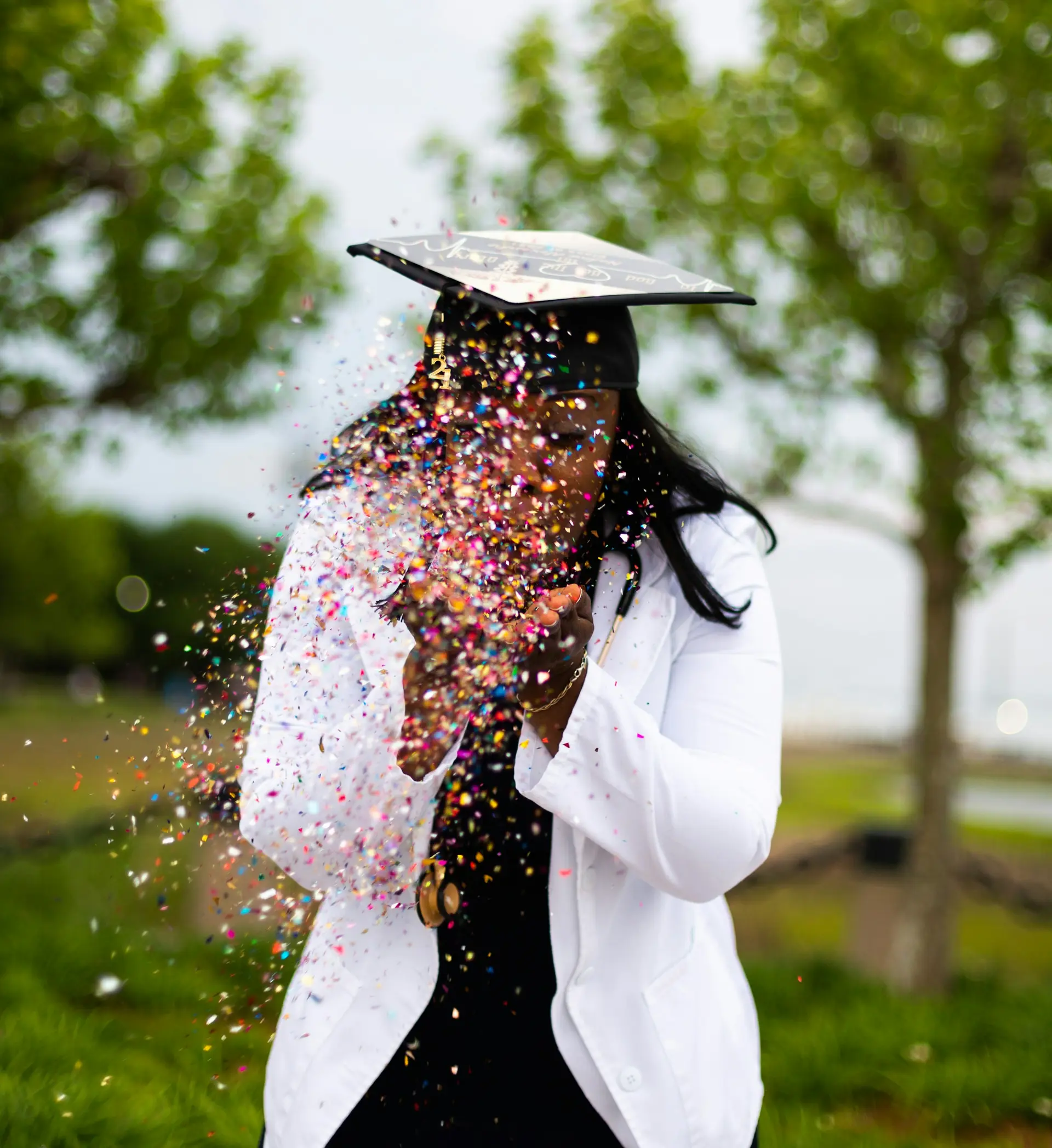 A smiling graduate in a cap celebrating outdoors
